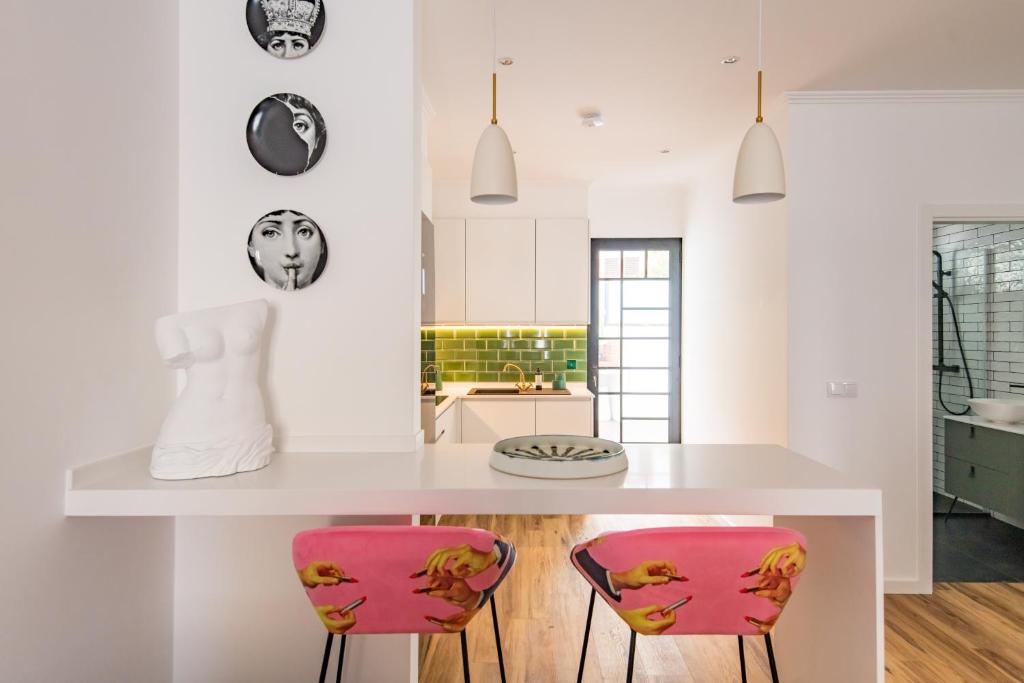 een keuken met een wit aanrecht en roze stoelen bij Eva Boutique Apartment in Funchal