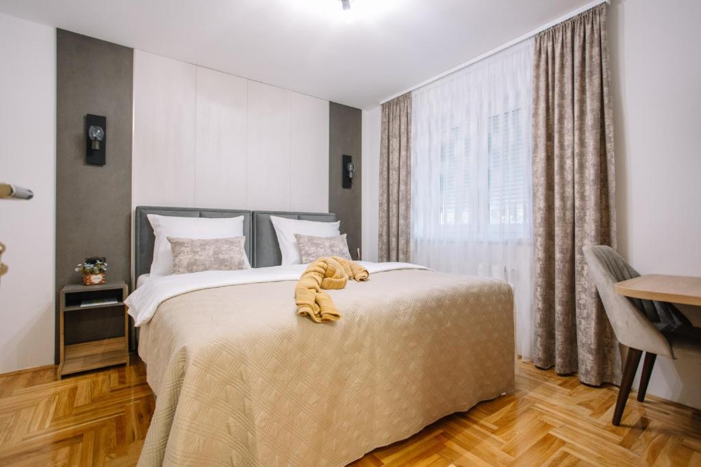 - une chambre avec un lit avec un animal rembourré dans l'établissement Apartments Hana City Center, à Livno