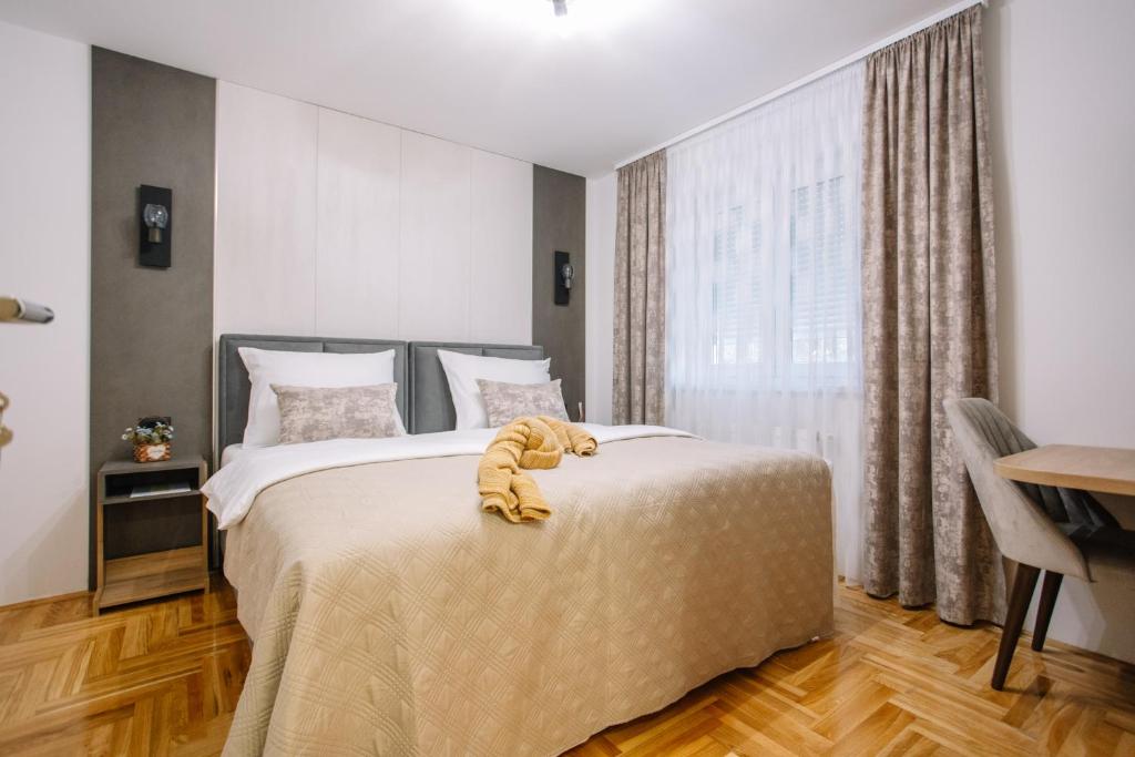 Un dormitorio con una cama con un animal de peluche encima. en Apartments Hana City Center, en Livno