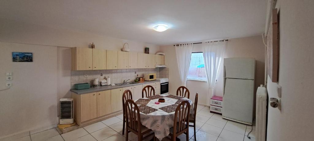 una cucina con tavolo, sedie e frigorifero di Hospitality up to 5 person's in Chios a Chio (Chios)