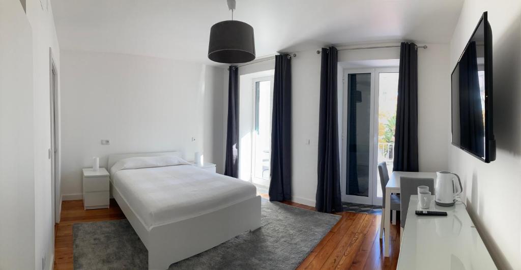 een slaapkamer met een wit bed en een aantal ramen bij Museum House in Funchal
