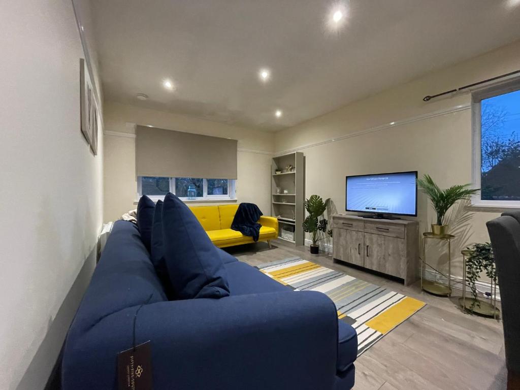 阿洛厄的住宿－The Riverside，客厅配有蓝色的沙发和电视