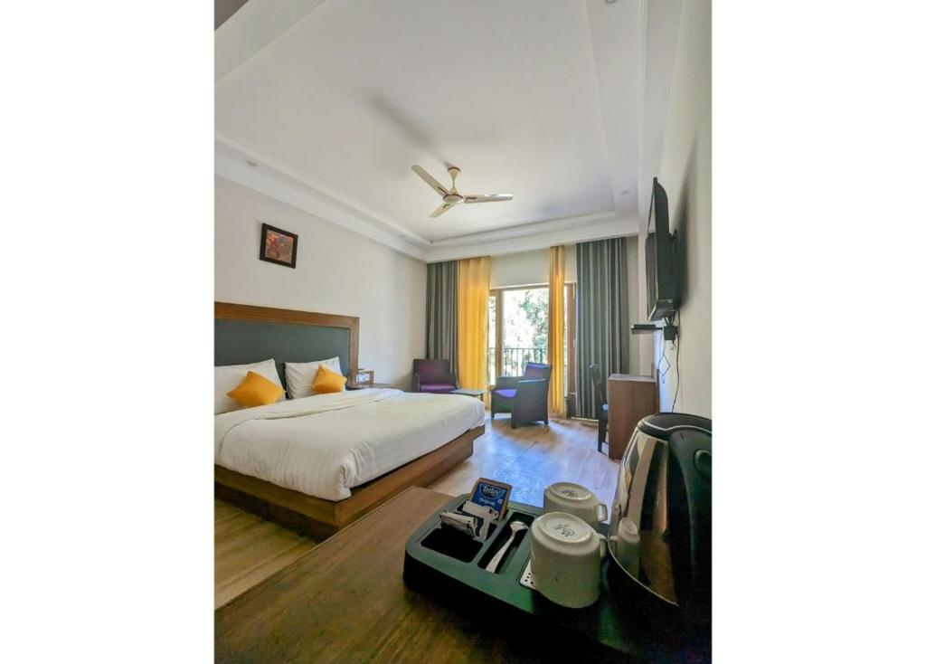 a hotel room with a bed and a desk at The 9 Oaks by BOP group of Stay and Cafe in Mussoorie