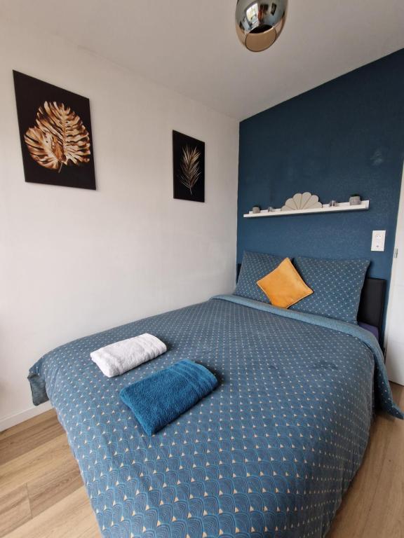 una camera da letto con un letto blu e cuscini sopra di Chambre privée - Béranger #2 ad Amiens