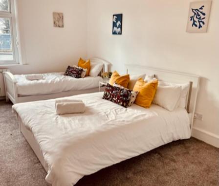 una cama blanca con almohadas en una habitación en Two Bedroom, Off-road Parking en Ludgershall