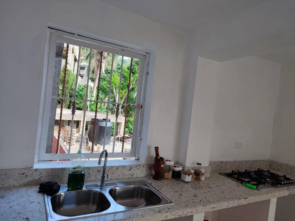 encimera de cocina con fregadero y ventana en Samana house en Santa Bárbara de Samaná