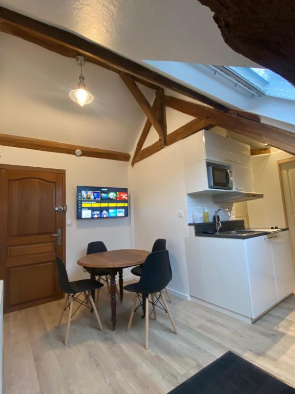 a kitchen and dining room with a table and chairs at 2 pièces les écuries du château in Bonnelles