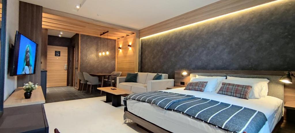 a bedroom with a large bed and a dining room at Woodside Story in Kopaonik
