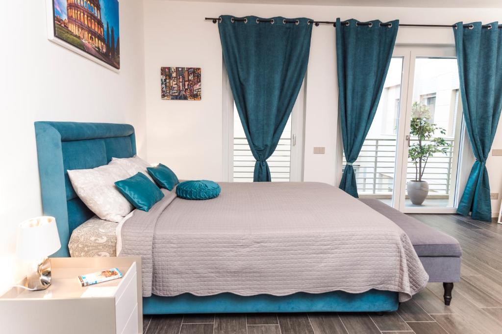 羅馬的住宿－The Rabbit Hole，一间卧室配有一张带蓝色窗帘的大床