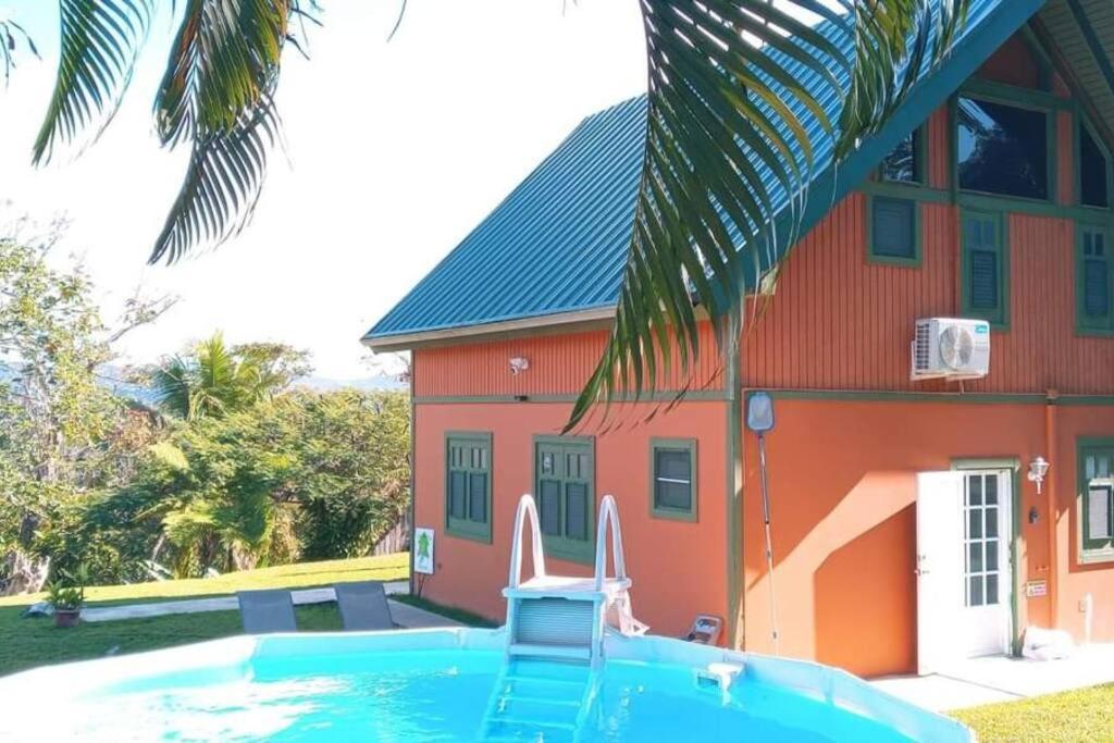 a house with a swimming pool in front of a house at Casa Campo Obymar/vista panorámica/piscina privada in Moca