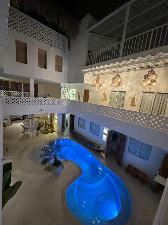 duży budynek z dużym niebieskim basenem w środku w obiekcie El Faro Hostel w mieście Arboletes