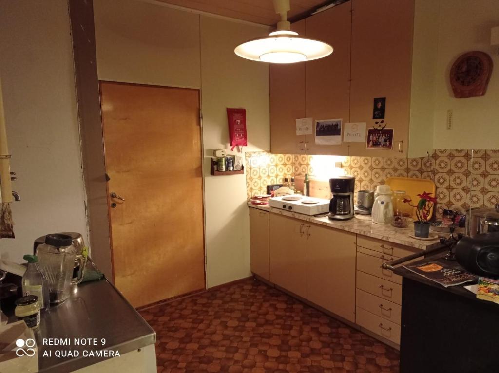 eine kleine Küche mit einer Theke und einer Tür in der Unterkunft Old Cozy Wood House in Rovaniemi