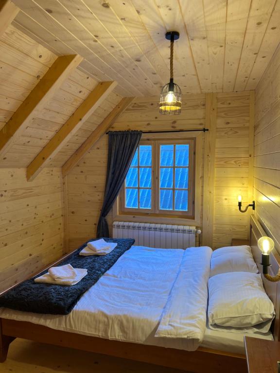 um quarto com uma cama grande num quarto de madeira em Planinska kuca Grujic em Kolašin