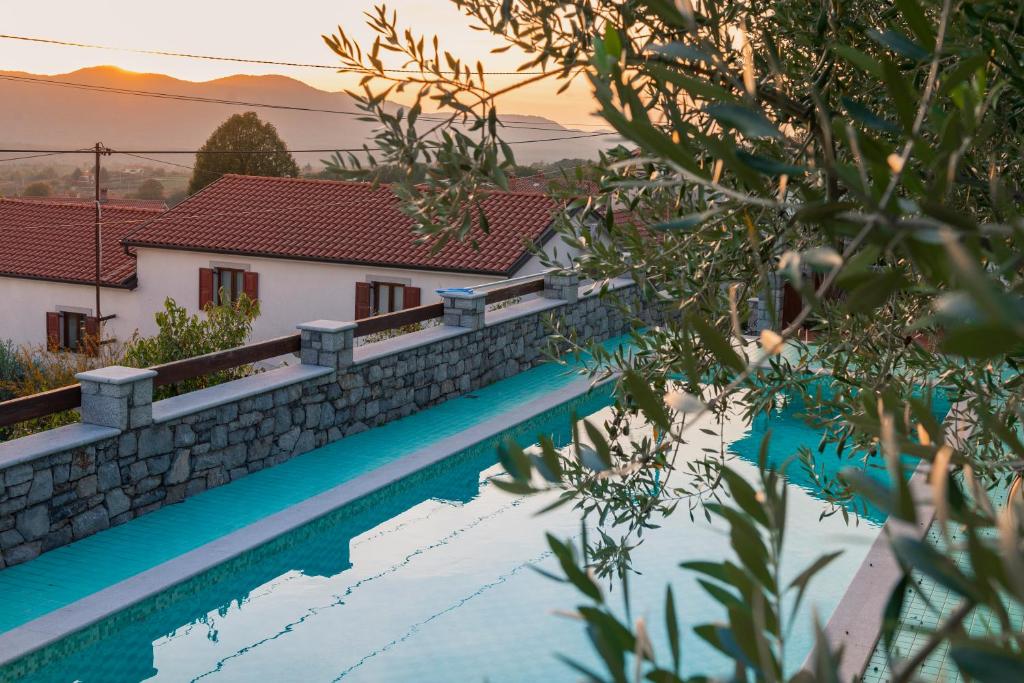 une villa avec une piscine dans un complexe dans l'établissement Tourist Farm Škerlj, à Dutovlje