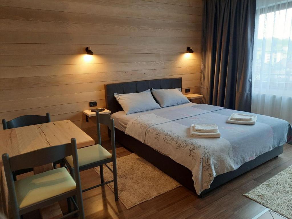 een slaapkamer met een bed, een tafel en een bureau bij Mrdja Apartments in Kolašin