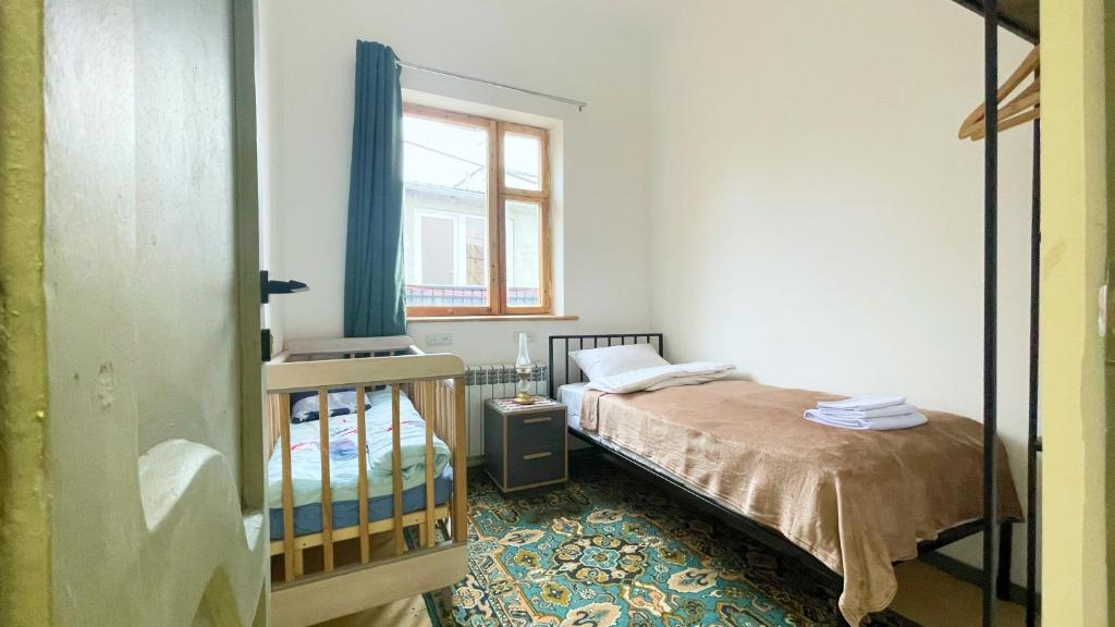een kleine slaapkamer met een bed en een raam bij Kotun Gyumri in Gjoemri