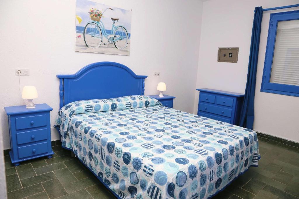 1 dormitorio con 1 cama azul y 2 mesitas de noche azules en Pensió Solivent, en L'Escala