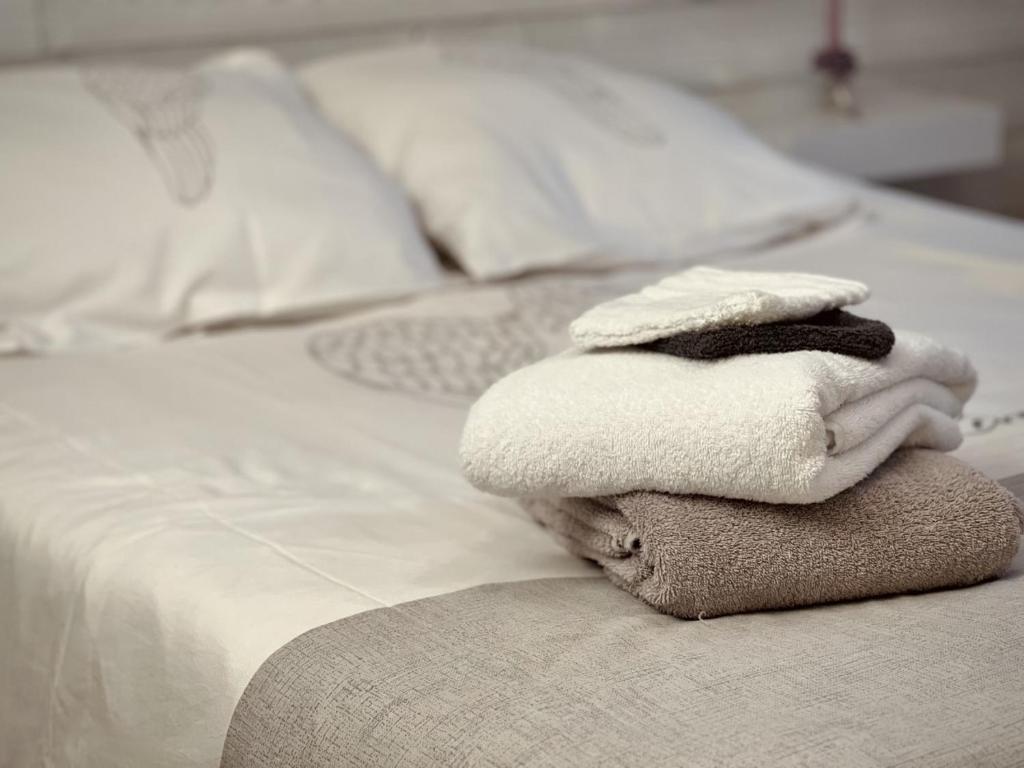 a stack of towels sitting on top of a bed at Chambre D'hôtes Francine et Gérard in Le Mans