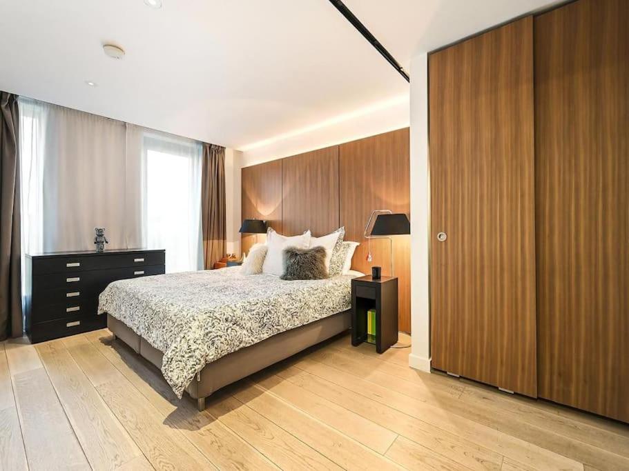 a bedroom with a bed and a wooden wall at Soho - Mayfair Luxury Central Apartment in London