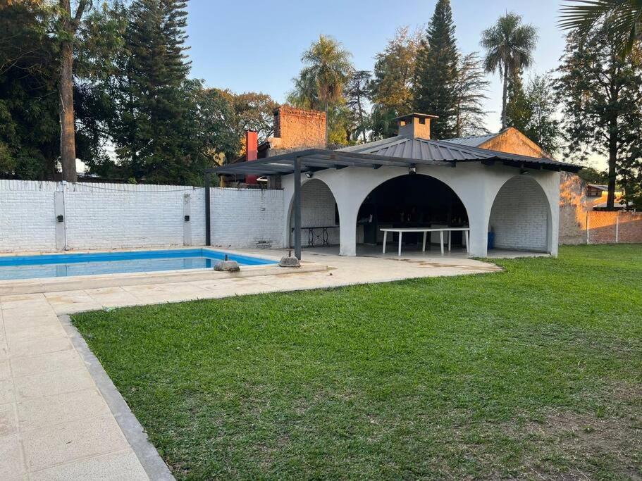 un cenador con piscina en un patio en Amplia casa Paso de la Patria en Paso de la Patria