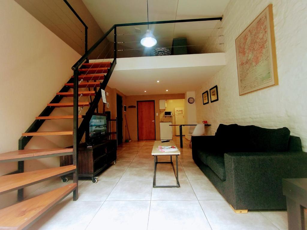 sala de estar con sofá verde y escalera en Económico y Hermoso Loft, cerca de todo! en Buenos Aires