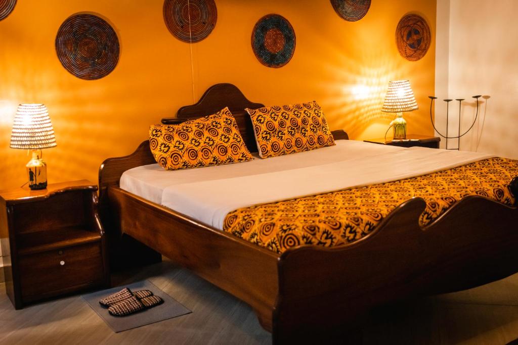 1 dormitorio con 1 cama grande y 2 lámparas en la pared en Tea House BNB en Kigali