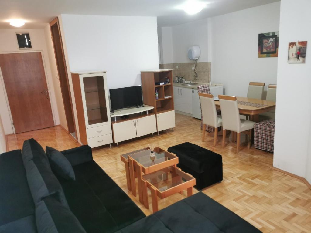 sala de estar con sofá negro y mesa en 007 Apartments - TC Global, Strumica, Macedonia, en Strumica