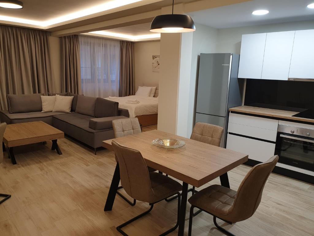 een keuken en een woonkamer met een tafel en een bank bij Olive Deluxe Apartment in Kardítsa