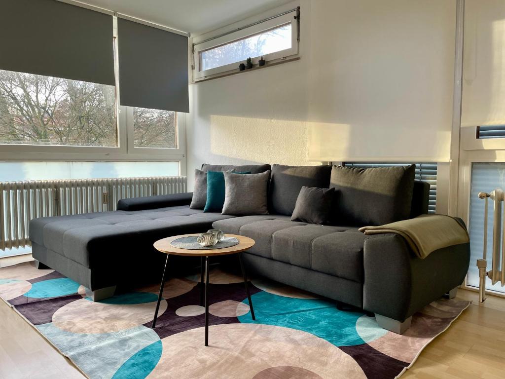 uma sala de estar com um sofá e uma mesa em LaMiaCasa Design Apartment near Ludwigsburg 2,5 rooms 75 sqm em Schwieberdingen