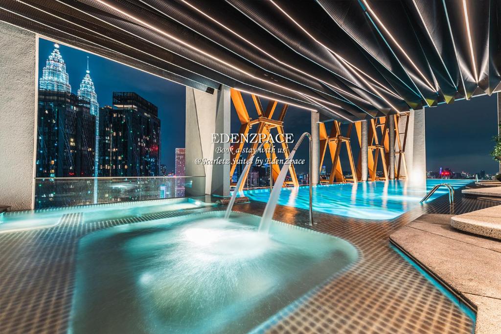 Scarletz Suites by Edenzpace @ KLCC Area في كوالالمبور: مسبح مطل على المدينة ليلا