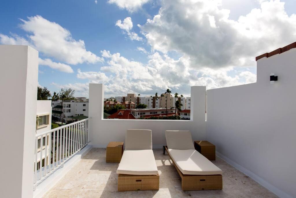 a balcony with two chairs and a view of a city at The Ultimate Escape Unpack Relax Enjoy in Punta Cana