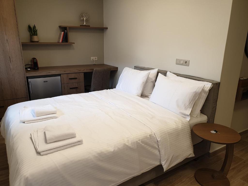 sypialnia z białym łóżkiem i 2 ręcznikami w obiekcie Olive Deluxe Room w mieście Kardítsa