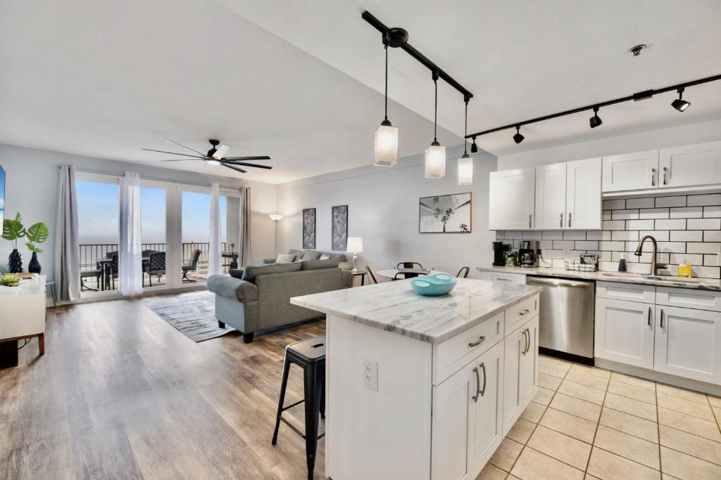 an open kitchen and living room in a home at Luxurious 4 Bedroom Condo! Gulf Views! Sleeps 10 & Easy Beach Access! by Dolce Vita Getaways PCB in Panama City Beach