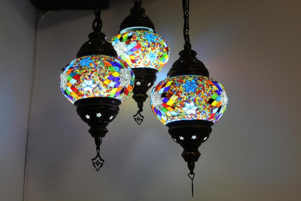 three stained glass lights hanging from a ceiling at Al pie del Camarín con parking gratis in Jaén
