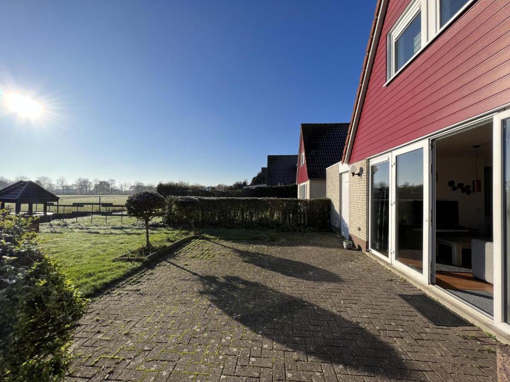 un vialetto di mattoni accanto a una casa rossa di Aan de Kis a Stevensweert