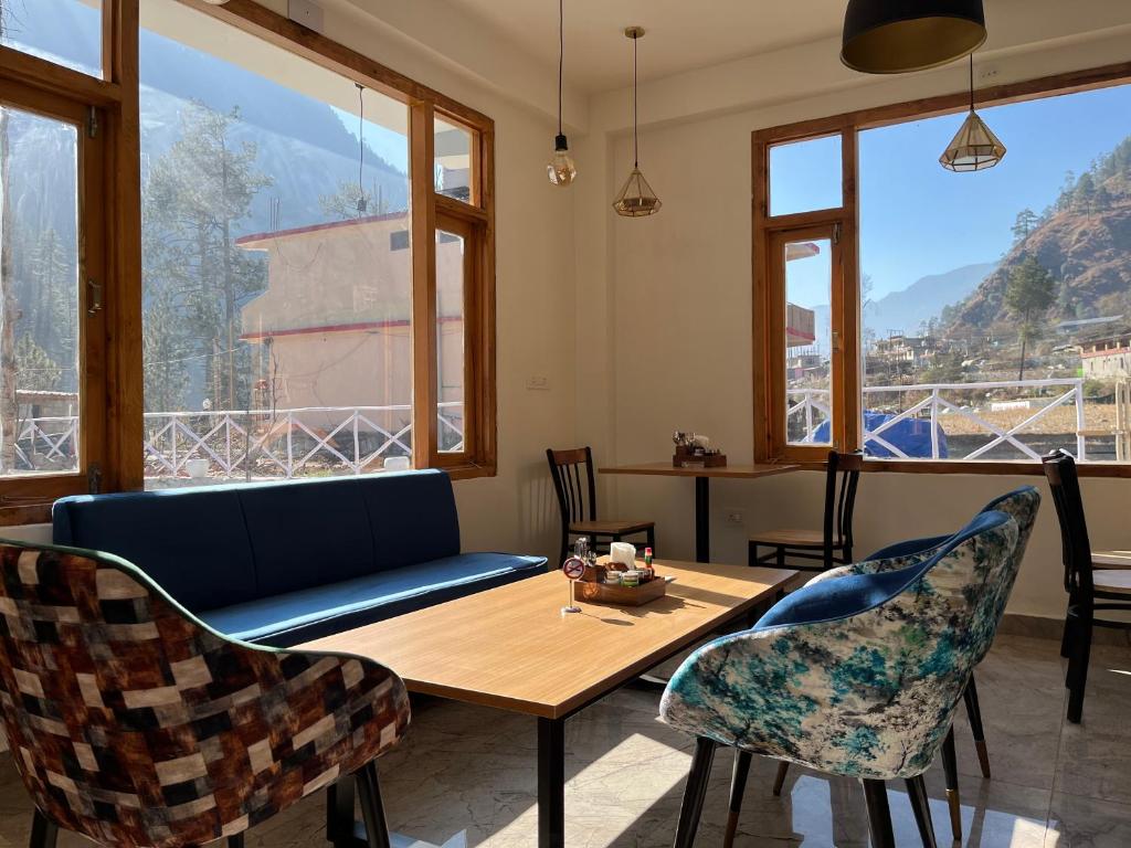 a living room with a couch and a table and chairs at Adinova in Kasol