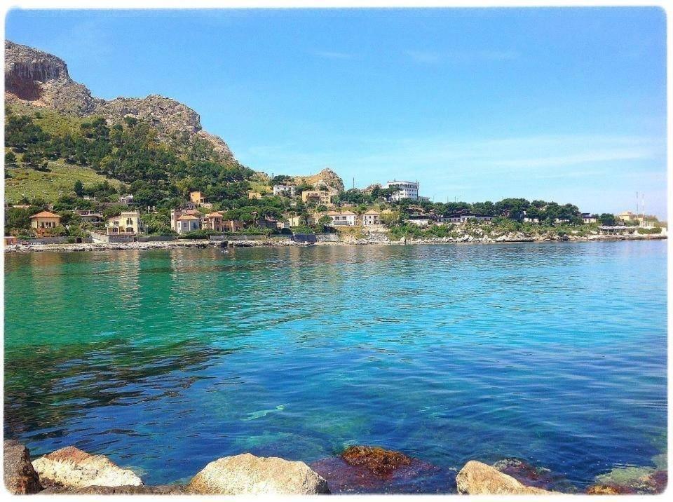 uma vista para uma massa de água com casas na costa em Bellevue del Golfo Hotel & Spa em Sferracavallo