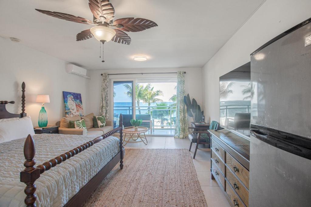 1 dormitorio con 1 cama y TV de pantalla plana en Beautiful Maho Condo Steps from the Beach, en Maho Reef
