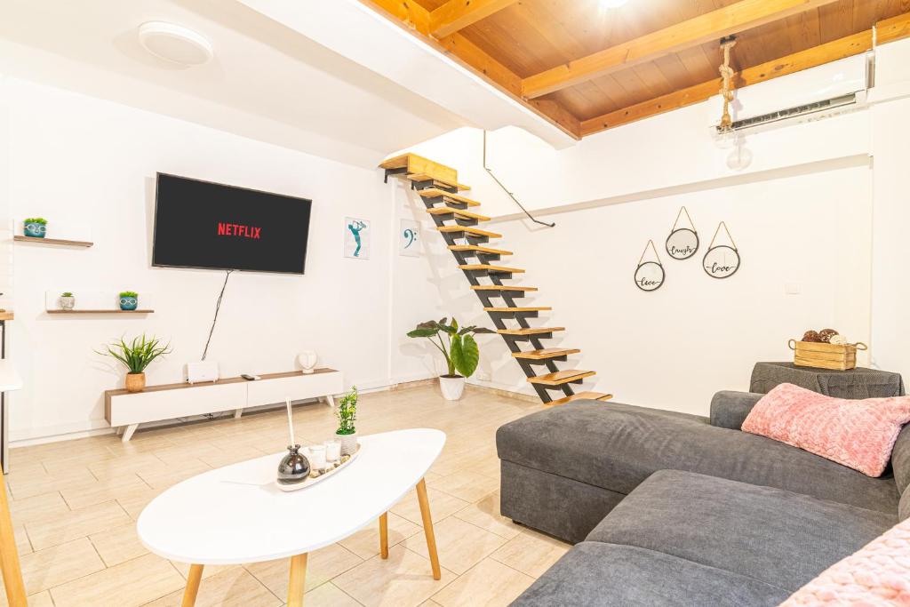 una sala de estar con un sofá y una mesa en New Loft in the Heart of City Center, en Heraclión