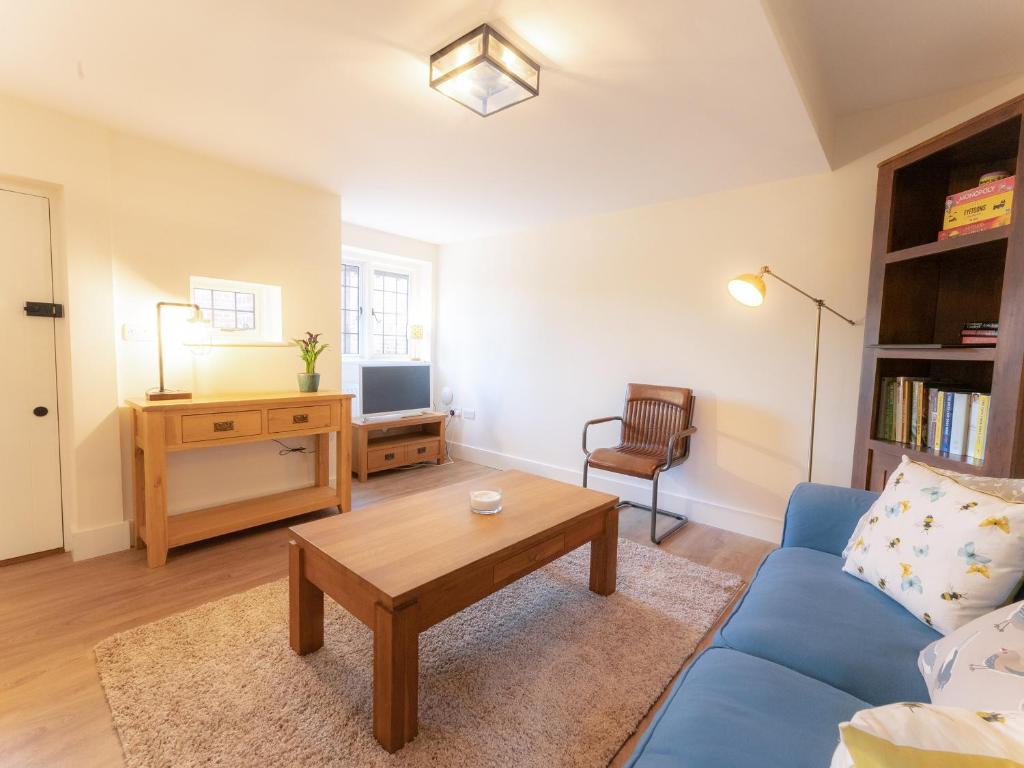 a living room with a blue couch and a table at The Annexe in Wisley