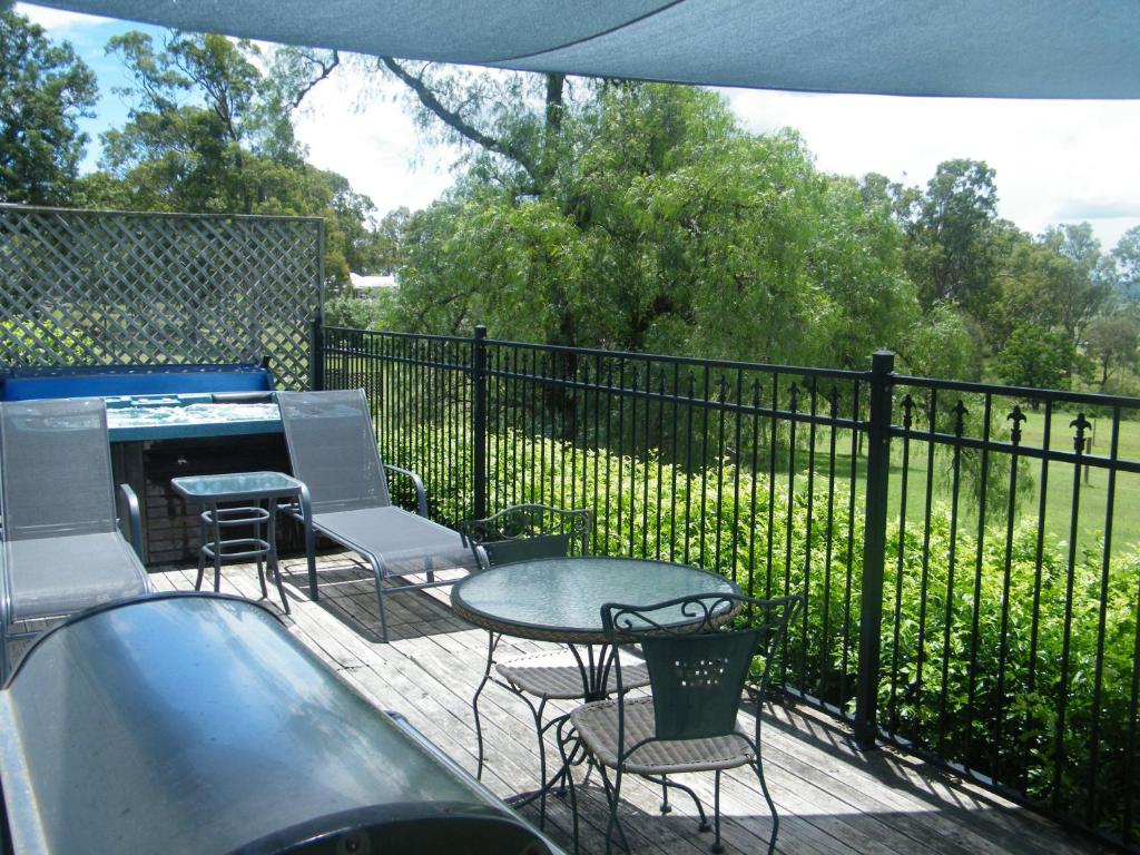 a patio with a table and chairs and a fence at St Peter's Fairview in Branxton