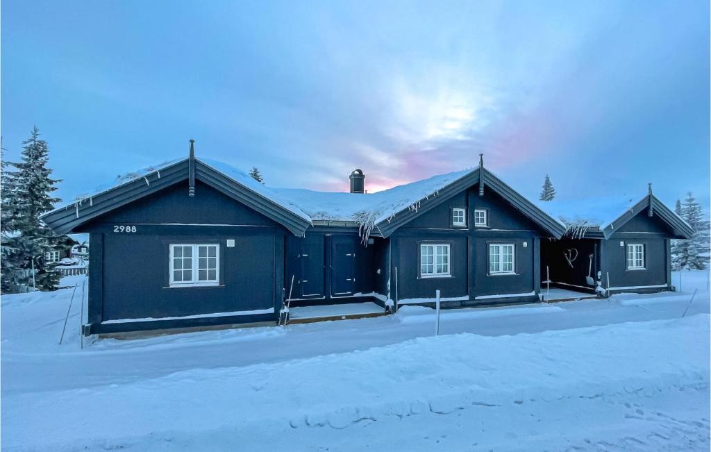 een blauw huis in de sneeuw met sneeuw bij Beautiful Home In Sjusjen With Wifi in Sjusjøen