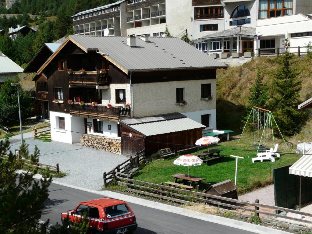 un camión rojo estacionado frente a una casa en Chalet les Ombrettes en Ceillac