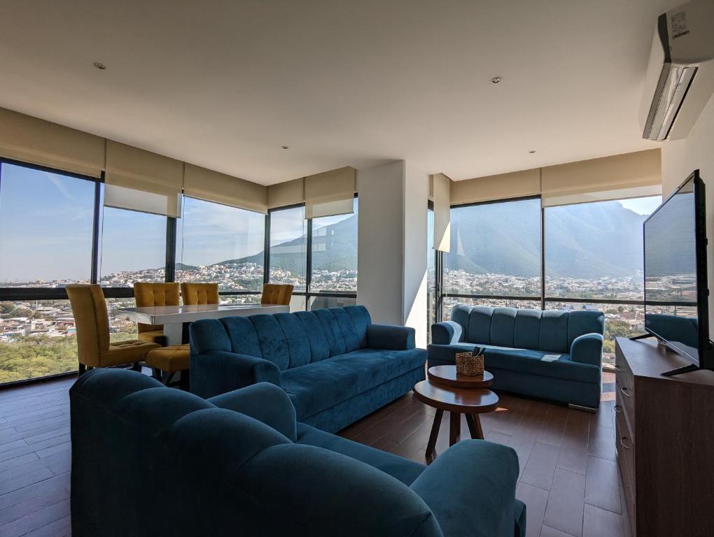 una sala de estar con sofás azules y una mesa. en Moderno Ubicacion Vistas Seguridad y Estilo, en Monterrey