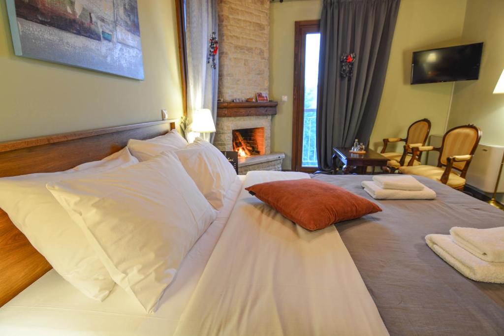 una camera da letto con letto, cuscini e camino di Ξενώνας Ίταμος a Kato Trikala Korinthias
