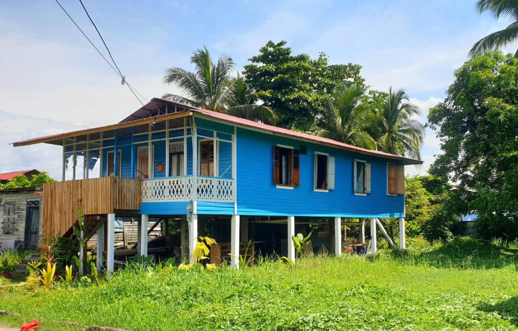 a blue house with a balcony on top at Old Bocasso in Bocas del Toro