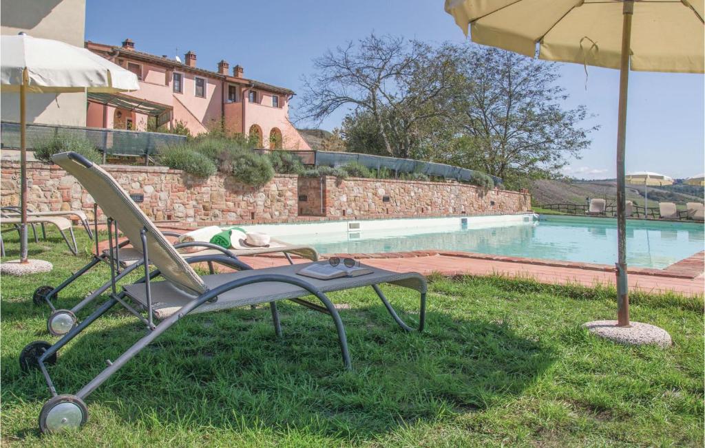 einen Stuhl und einen Regenschirm neben einem Pool in der Unterkunft Calanchi in Collelungo