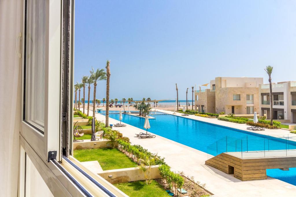 una finestra con vista sulla piscina. di Mangroovy Seaview 1BR Beach and Pool Free access a Hurghada