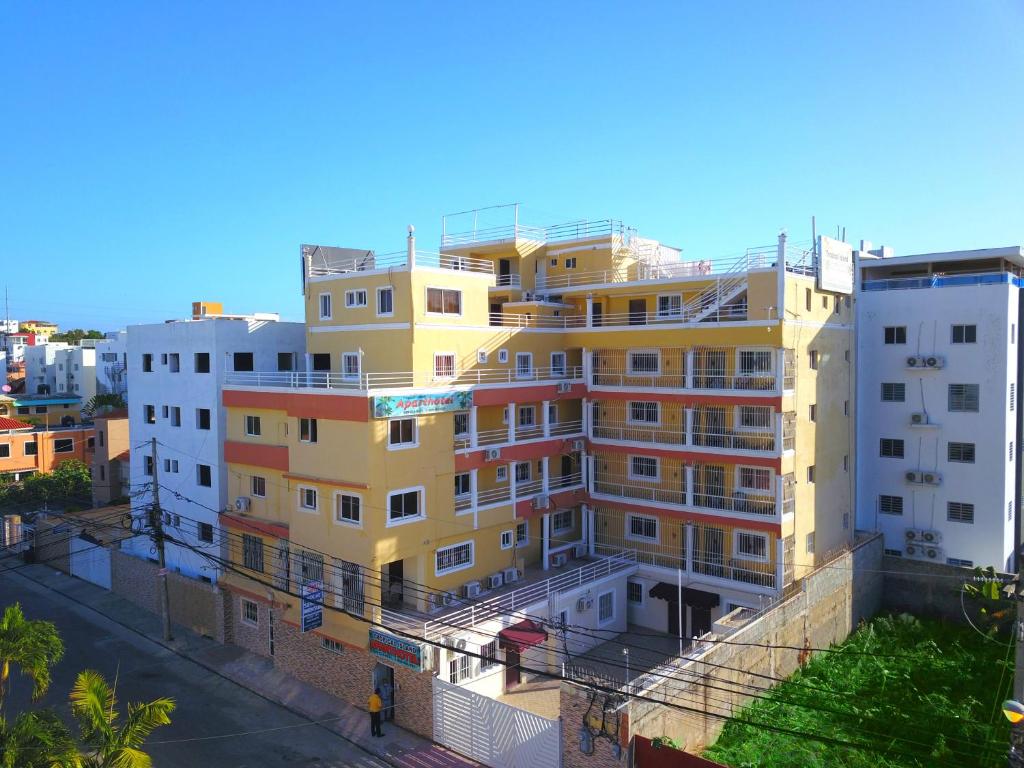 un edificio alto amarillo al lado de una calle en Tropical Island Aparthotel, Budget Rooms & Family Apartment Rentals, en Santo Domingo