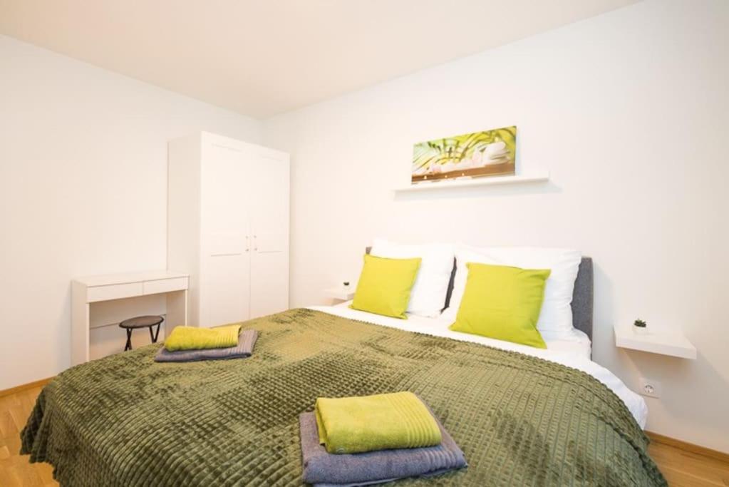 a bedroom with a large bed with green pillows at Premium City Apartment with balcony! Free Garage Parking included! in Vienna